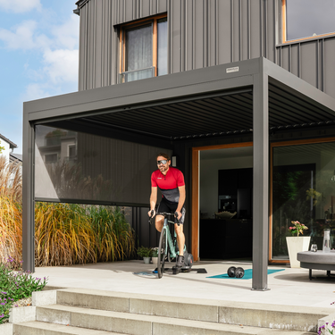 Moderne Pergolux Pergola als überdachter Trainingsbereich mit Rennrad und Fitness-Equipment.