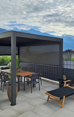 Pergolux Pergola auf einer modernen Terrasse mit seitlichen Screens, Essbereich und Blick auf die Berge.