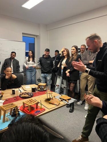 Teammitglieder bei einem internen Pergolux-Workshop mit Miniaturmodellen von Pergolen auf dem Tisch.
