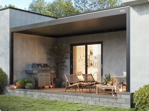 Maßgeschneiderte Pergolux Pergola als integrierte Terrassenüberdachung an einem modernen Haus mit Lounge-Bereich und Grill.