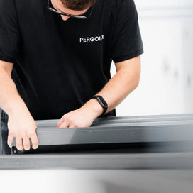 Pergolux-Mitarbeiter bei der sorgfältigen Montage eines Bauteils